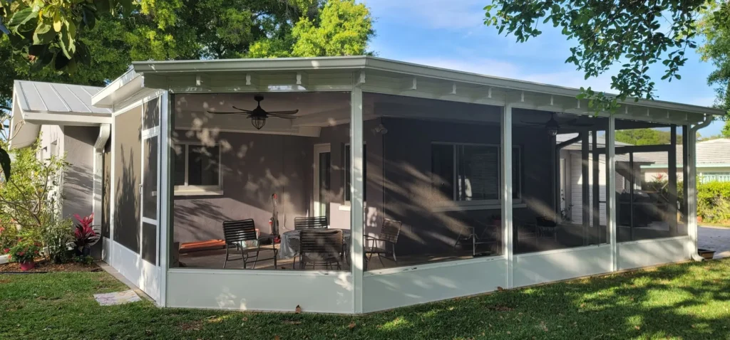 New residential screened porch with solid roof and outdoor furniture, installed by All Star Sunrooms in Florida.
