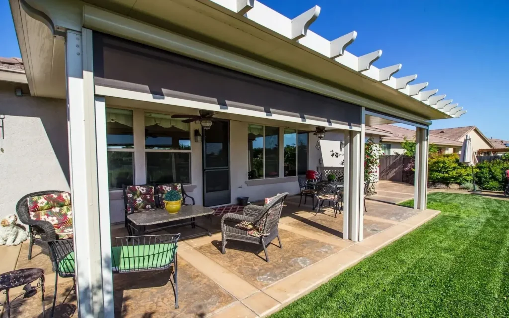 Motorized louvered patio cover and pergola by All Star Sunrooms offering sun protection over an outdoor living space.