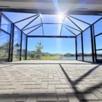 Interior perspective showing the wide-open feel of a large-span aluminum screen cage on a patio.